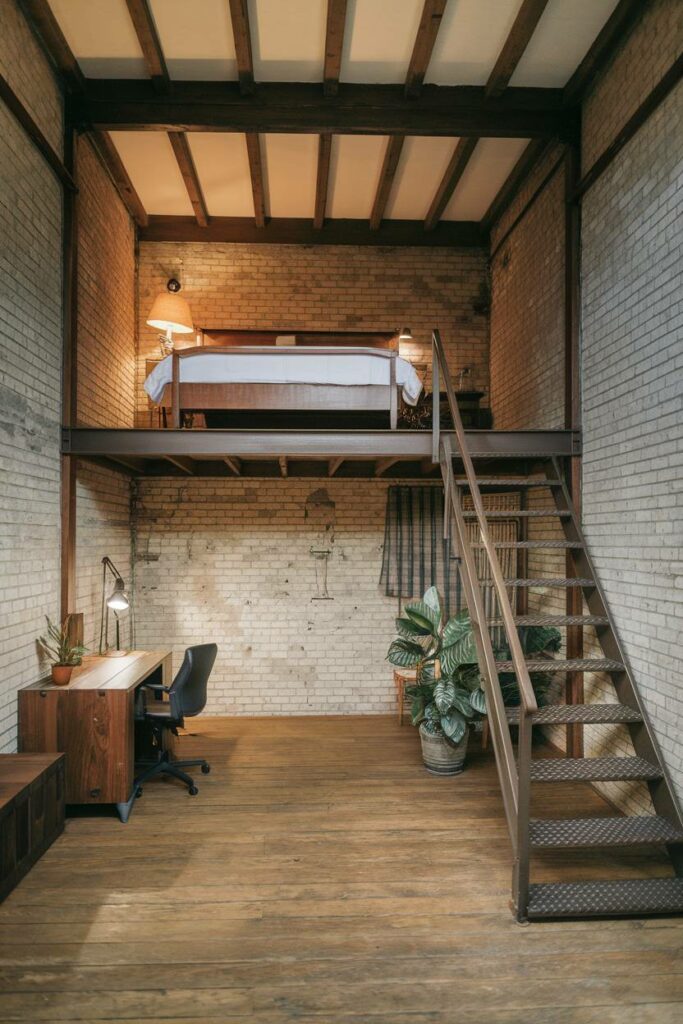 19. Metal Staircase with Earthy Hue Industrial Bedroom